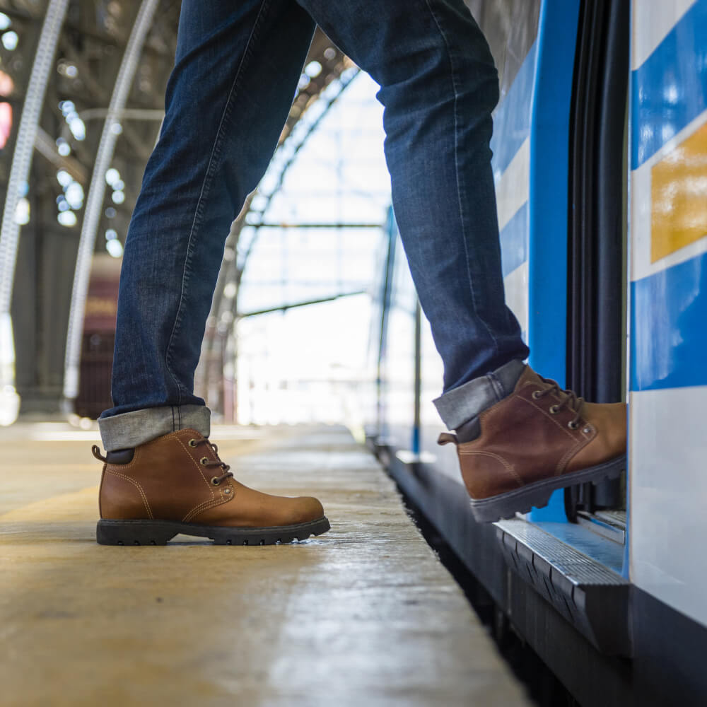 Fahrgast, der am Bahnhof in eine Bahn einsteigt.
